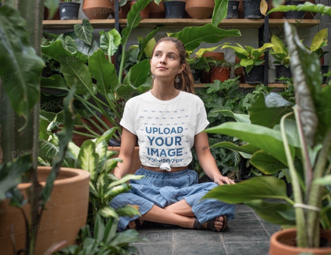 t-shirt mockup seorang wanita duduk di rumah kaca